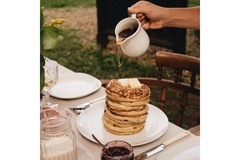 Image Honey being poured on top of pancakes.